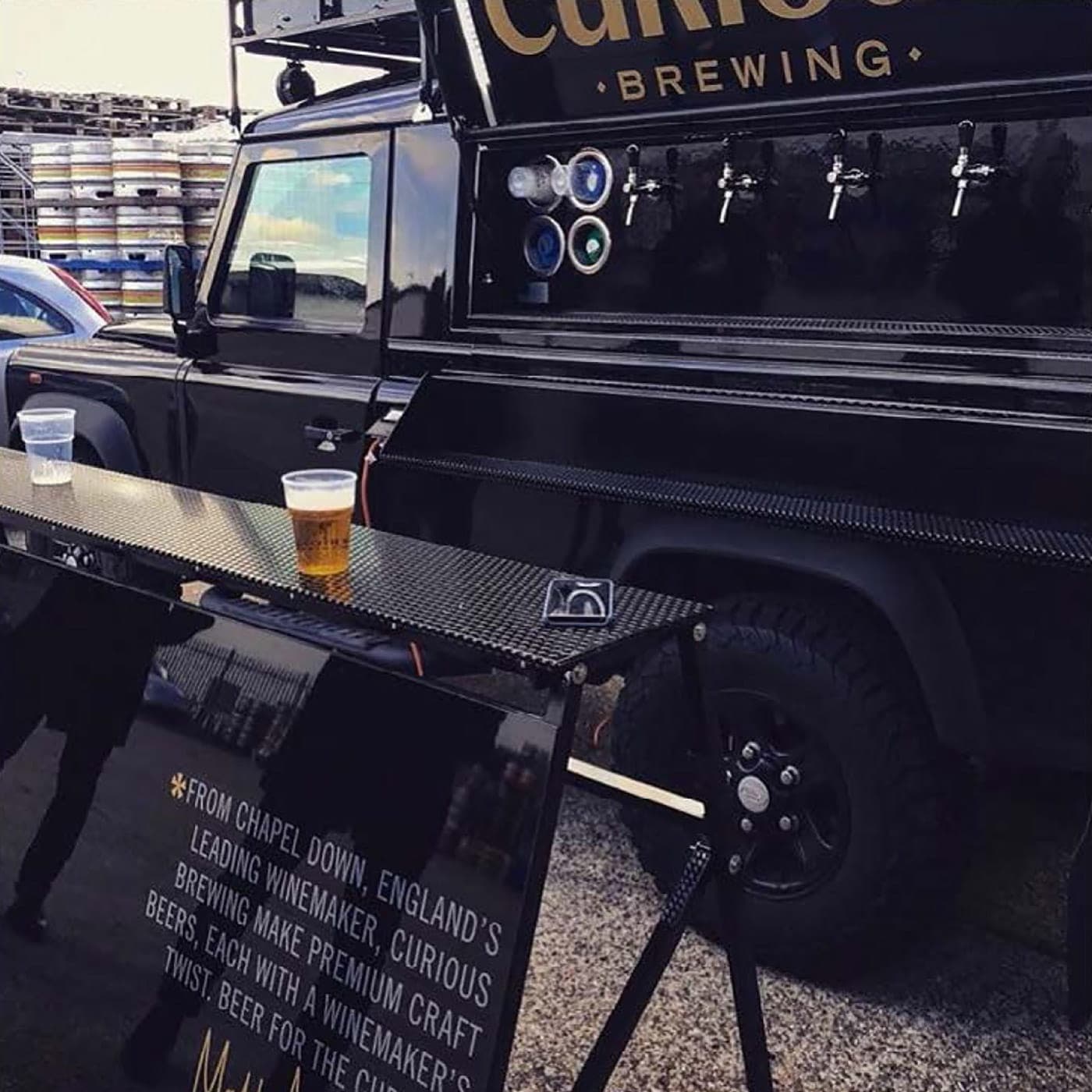 The Curious Brewing Land Rover mobile bar with built-in beer taps, serving at an event